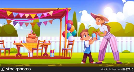 Birthday party on backyard with woman gives gift box boy. Vector cartoon illustration of garden with festive decoration, wooden tent, cake with candles, balloons and happy child. Birthday party on backyard with woman and boy