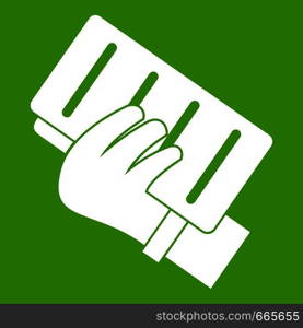 Brick in a hand icon white isolated on green background. Vector illustration. Brick in a hand icon green