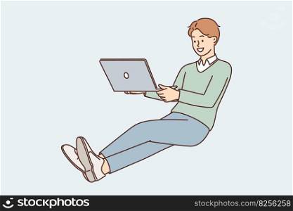 Business man with laptop on lap hovers in zero gravity doing work remotely and communicating with colleagues via Internet. Guy freelancer with laptop works as copywriter or programmer. Business man with laptop on lap hovers in zero gravity doing work remotely via Internet