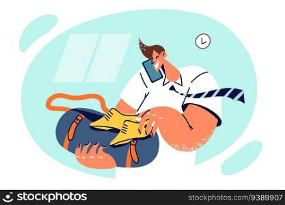 Busy man puts shoes in bag for going on business trip and talks on phone discussing travel plan. Successful business man prepares clothes for going to workout in fitness club after working day. Busy man puts shoes in bag for going on business trip and talks on phone discussing travel plan