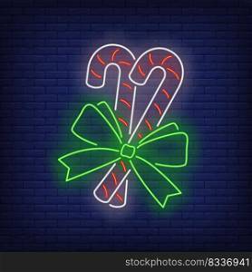 Candy canes neon sign. Sugar canes, ribbon, bow. Vector illustration in neon style for topics like Christmas, dessert, sweet
