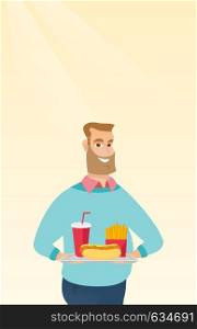 Caucasian man holding a tray with fast food. Young man having lunch in a fast food restaurant. Happy man with fast food. Unhealthy nutrition concept. Vector flat design illustration. Vertical layout.. Man holding tray full of fast food.