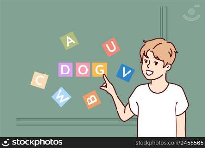 Child is studying letters from alphabet to learn how to read, and stands near blackboard, pointing finger at word dog. Education for children and study alphabet to prepare for entry into school. Child is studying letters from alphabet to learn how to read, and stands near blackboard