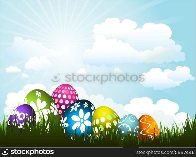 Colourful Easter eggs nestled in grass against a sunny sky&#xA;