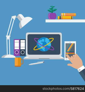 Concept of workplace with hands holding smartphone, laptop, lamp and different office objects