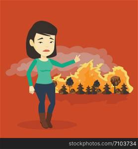 Concerned asian woman pointing at forest in fire. Frustrated woman standing on the background of a big forest fire. Environmental destruction concept. Vector flat design illustration. Square layout.. Woman standing on the background of wildfire.