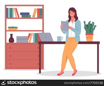 Confident young businesswoman in yellow trousers leaned on the desktop, tablet in hands, laptop on the table, bookcase, books, documents, folders. Work office space. Pot flower. Flat vector image. Young woman in office, with tablet in hand, work desk, laptop, office space. Flat vector on white