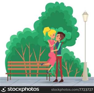 Cute happy smiling couple on a date in the park. The guy picks up the girl in his arms outdoors. People in relationship hugging in the open area against the background of green trees summer day. Cute happy smiling couple on a date in the park. The guy picks up the girl in his arms outdoors