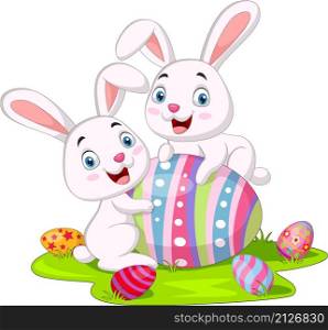 Cute two little bunnies with Easter egg in the grass