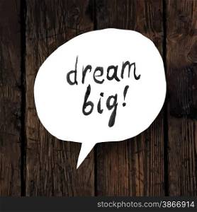 ""Dream big" lettering in speech bubble on wooden texture"