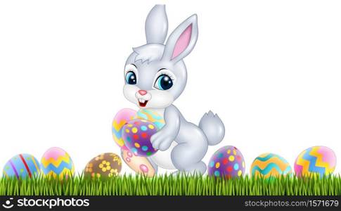 Easter bunny with decorated Easter eggs in a field