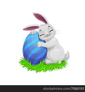 Easter holiday vector bunny or rabbit on easter egg hunt, egghunting party. Gray cartoon bunny on green grass holding a painted egg with blue stripe pattern, Christian religion holiday. Easter funny gray bunny with egg
