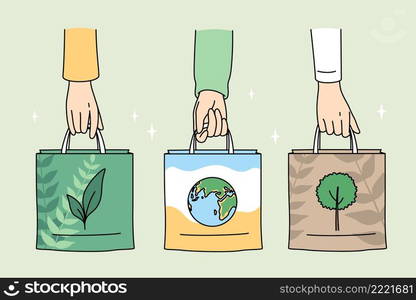 Ecology care and eco-friendly things concept. Human hands holding eco-friendly bags with pictures of plant planet and tree vector illustration . Ecology care and eco-friendly things concept.