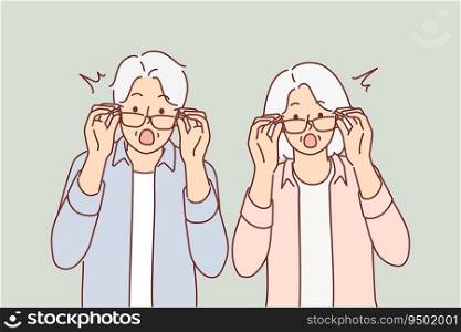 Elderly surprised couple takes off glasses and looks at screen after learning about big promotions and sales for shopping. Surprised grandparents shout wow and feel excited about unexpected news. Elderly surprised couple takes off glasses and looks at screen after learning about big promotions 