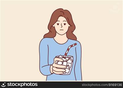 Emotionless girl holds glass full of sugar with straw symbolizing unhealthy nutrition leading to diabetes. Woman drinking drinks with too much sugar needs diet to avoid insulin problems . Emotionless girl holds glass full of sugar with straw symbolizing unhealthy nutrition