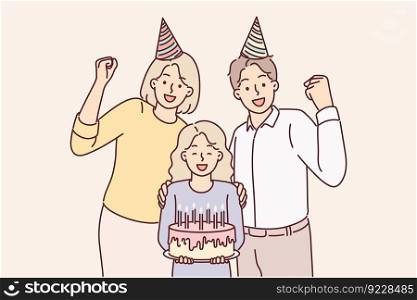 Family of parents with daughter celebrating birthday posing with cake and candles for joint photo. Mother and father together with pre-teenage girl celebrating birthday party making joyful gestures . Family of parents with daughter celebrating birthday posing with cake and candles for joint photo