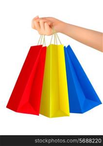 Female hand holding colorful shopping bags. Vector.