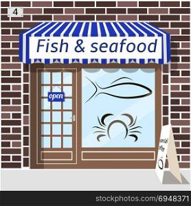 Fish and seafood shop.. Fish and seafood shop building. Fish and crab sticker on window. Blue awnings. Brown brick facade. Advertising panel at the fore.