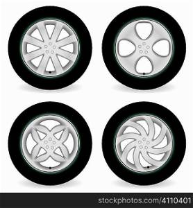 Four car tires with alloy wheels of different designs