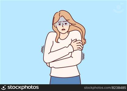 Freezing woman hugging shoulders trying to keep warm and feeling chills after contracting flu infection or fever. Freezing girl in sweater dreams of warm house to wait out cold weather . Freezing woman hugging shoulders trying to keep warm and feeling chills after contracting flu