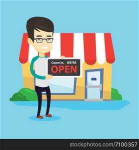 Friendly asian shop owner holding an open signboard. Cheerful smiling shop owner standing in front of small store. Man inviting to come in his shop. Vector flat design illustration. Square layout.. Asian shop owner holding open signboard.