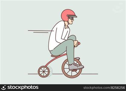 Funny man drives miniature bicycle rushing to meeting or relaxing in spare time. Cheerful guy in protective helmet driving toy bike for concept of business acceleration or rush in management. Funny man drives miniature bicycle while rushing to meeting or relaxing in spare time
