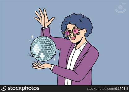 Funny man with disco ball with curly wig on head came to nightclub or dance floor to have fun and relax. Young guy enjoys atmosphere of music festival or disco party for party people. Funny man with disco ball with curly wig on head came to nightclub or dance floor to have fun