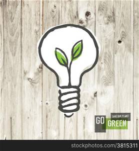 Green eco energy concept, plant growing inside the light bulb, on wooden texture.