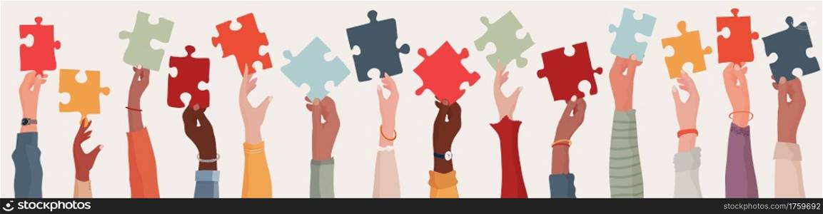 Group of multi-ethnic business people with raised arms holding a piece of jigsaw. Colleagues of diverse races and culture. Cooperate and collaborate. Concept of teamwork and success