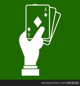 Hand holding playing cards icon white isolated on green background. Vector illustration. Hand holding playing cards icon green