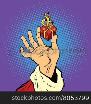 Hand of Santa Claus and a small gift, pop art retro vector illustration. Holidays New year and Christmas