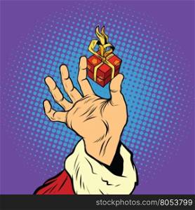 Hand of Santa Claus and a small gift, pop art retro vector illustration. Holidays New year and Christmas