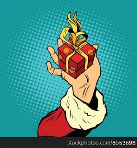 Hand of Santa Claus with gift, pop art retro vector illustration. Holiday New year and Christmas