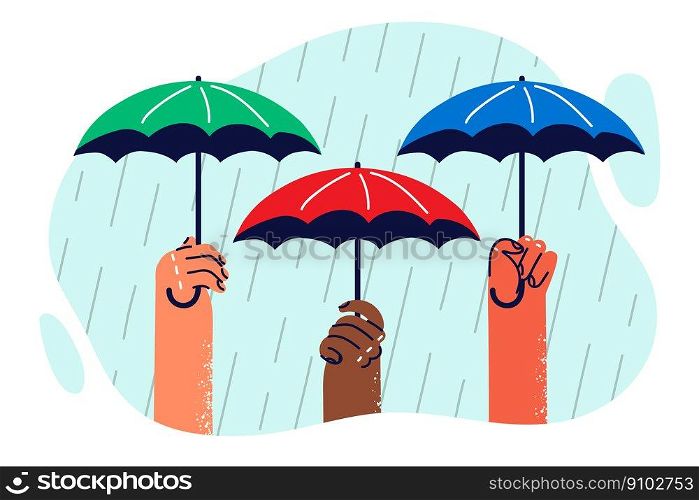 Hands of people with umbrellas protecting from heavy rain symbolizing onset of autumn with precipitation. Umbrellas and rain as metaphor for protecting multiethnic diversity over ethnic disputes. Hands of people with umbrellas protecting from heavy rain symbolizing onset of autumn