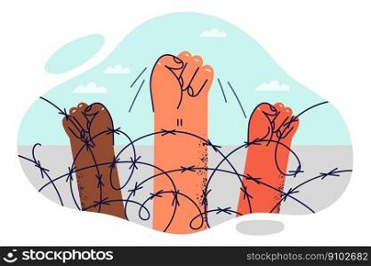 Hands of protesters are clenched into fist near barbed wire at border intended to restrict movement of illegal migrants. Fist is symbol of protest action of prisoners against deprivation of liberty . Hands of protesters are clenched into fist near barbed wire restrict movement of illegal migrants