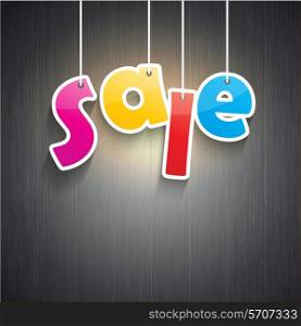 Hanging sale stickers on a wooden background