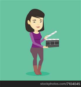 Happy asian woman working with a clapperboard. Smiling woman holding an open clapperboard. Cheerful woman holding blank movie clapperboard. Vector flat design illustration. Square layout.. Smiling woman holding an open clapperboard.