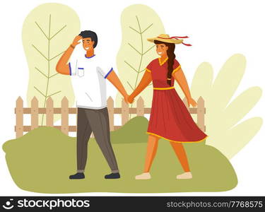 Happy couple in love is walking in sunny day. Smilling guy is walking with girl in hat outdoors. Free time activity in garden. People in relationship walk by handle in windy weather in city park. People in relationship walk by handle in windy weather. Smilling guy with girl in hat outdoors