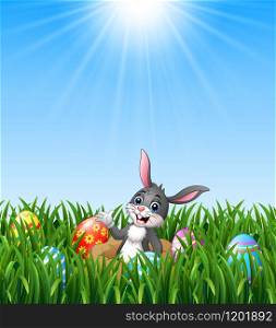 Happy easter rabbit out of holes in the ground with easter eggs in the grass background