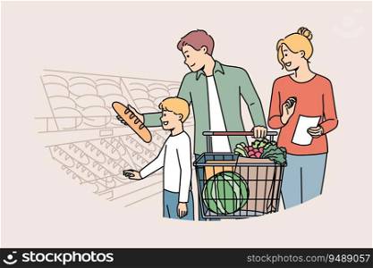 Happy family is shopping in supermarket, standing with trolley near shelves with fresh bread. Boy visits grocery store with parents choosing pastries or bread, for concept of healthy diet. Happy family is shopping in supermarket, standing with trolley near shelves with fresh bread