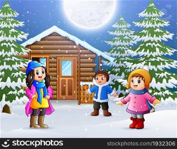 Happy kids to wear winter clothes and play in front of a snowy wooden house