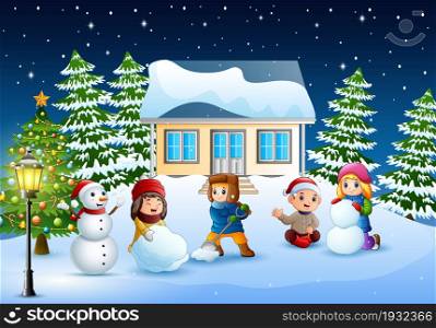 Happy kids wearing a winter clotes making a snowman in christmas day
