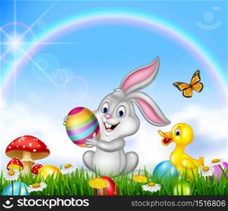 Happy little bunny holding Easter egg with nature background