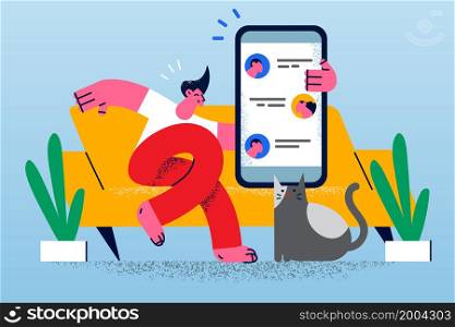 Happy man sit on sofa relax at home use cellphone text message online with friends. Smiling guy rest indoors communicate chat on smartphone. Communication, technology. Vector illustration. . Happy guy communicate online on cellphone