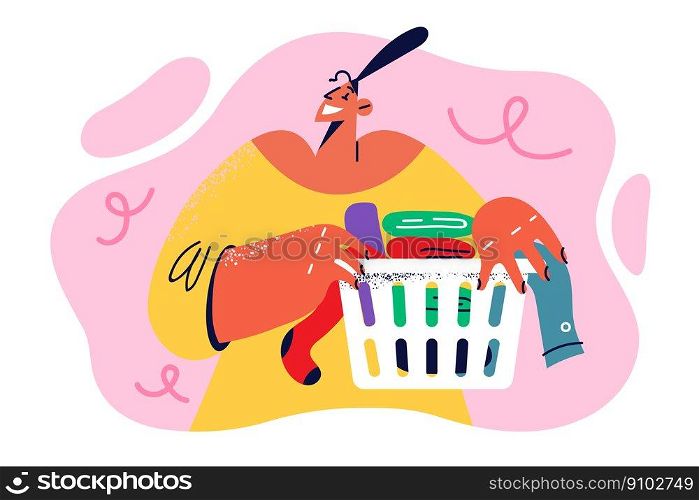 Happy woman housewife holding basket with clean clothes and towels after washing enjoying housework. Positive housewife carries colorful textiles to washing machine doing housekeeping work. Happy woman housewife holding basket with clean clothes and towels after washing enjoying housework