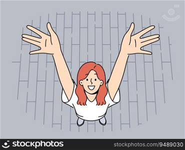 Happy woman raises hands up standing on street pavement and smiles looking at screen. Happy girl in short-sleeved t-shirt rejoices at opportunity to go for walk and absence of important things to do. Happy woman raises hands up standing on street pavement and smiles looking at screen