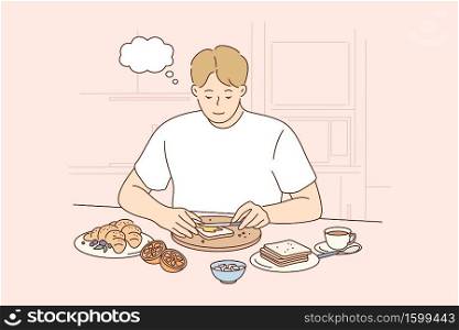 Health, care, food, thinking concept. Young thoughtful smiling pensive man boy character making toast spreading butter on bread at breakfast lunch dinner at home kitchen. Healthy eating lifestyle. Health, care, food, thinking concept