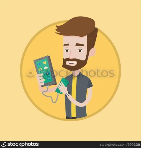 Hipster man recharging his smartphone with mobile phone portable battery. Young man holding a mobile phone and battery power bank. Vector flat design illustration in the circle isolated on background.. Man reharging smartphone from portable battery.