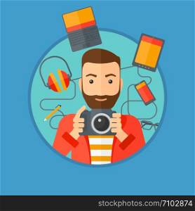 Hipster man with the beard taking photo with digital camera. Young man surrounded with gadgets. Man using many electronic gadgets. Vector flat design illustration in the circle isolated on background.. Young man surrounded with his gadgets.