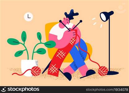 Home leisure hobbies and knitting concept. Young smiling man cartoon character sitting at home in armchair knitting scarf of red wool vector illustration . Home leisure hobbies and knitting concept